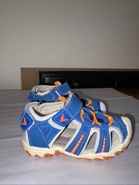 White Apakowa closed toe kids shoes with orange and blue accents